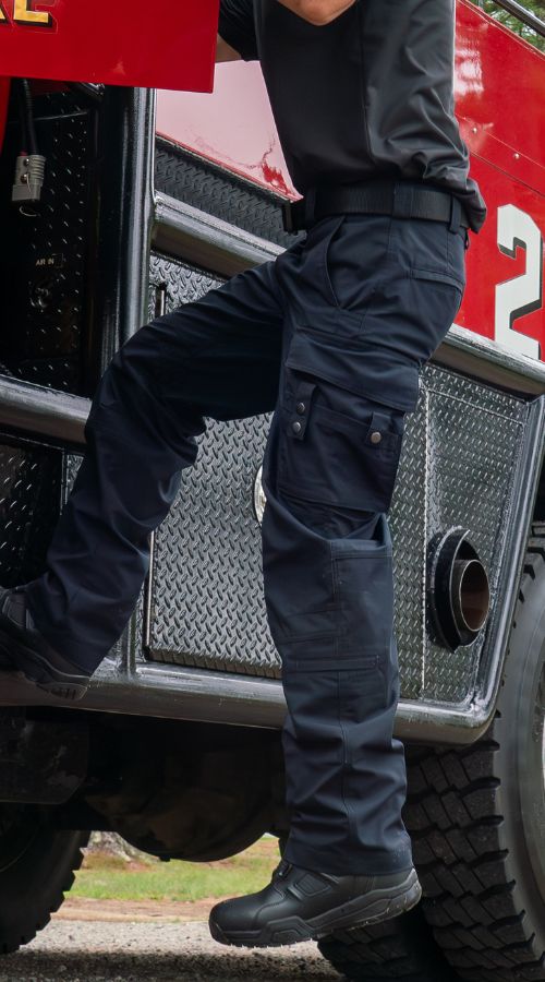Firefighter shown wearing FlexRS EMT pants while climbing in to engine