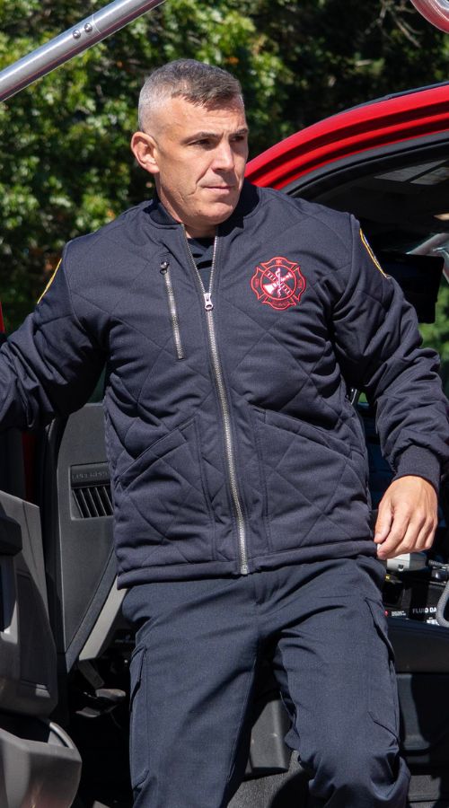 Firefighter at the station wears the Blauer Quilted Bomber Jacket
