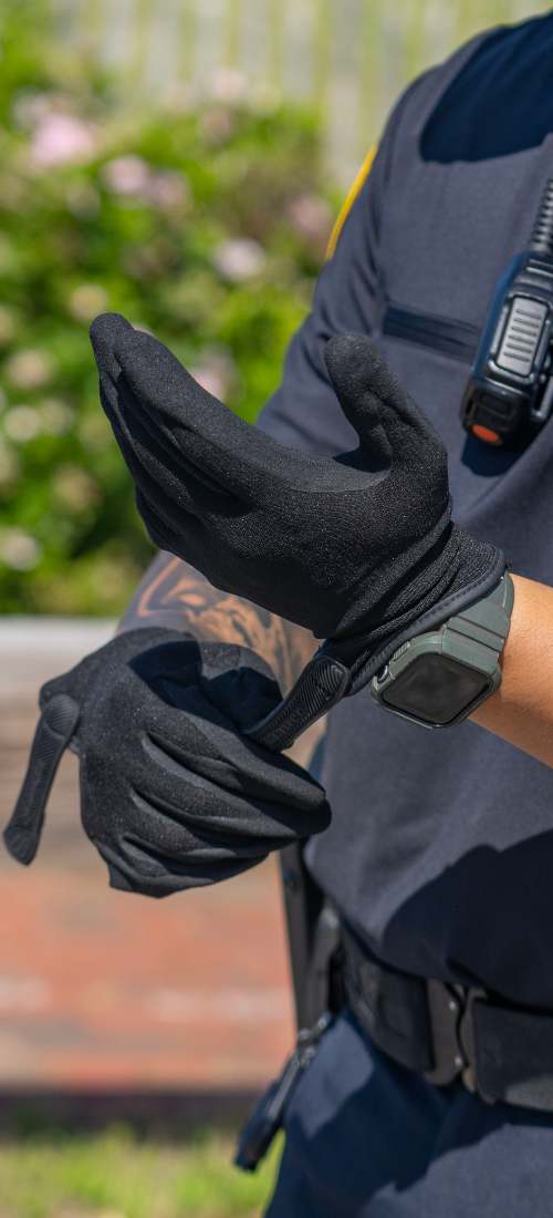 A bike officer puts on protective gloves in preparation for their bike patrol